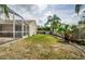 A view of the backyard featuring the screened-in back patio and grassy area at 9229 Dayflower Dr, Tampa, FL 33647