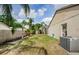 Backyard showing tropical landscaping, the side of the house, and partial back patio at 9229 Dayflower Dr, Tampa, FL 33647