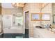 Bathroom features a tub, double sinks, palm tree wallpaper, framed art and lots of natural light at 9229 Dayflower Dr, Tampa, FL 33647