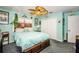 Cozy bedroom featuring a ceiling fan, aqua walls, wood trim and an inviting queen bed with a blue comforter at 9229 Dayflower Dr, Tampa, FL 33647