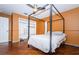 Bedroom featuring orange walls, wood floors and a black framed queen bed with white linens at 9229 Dayflower Dr, Tampa, FL 33647