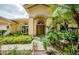 Welcoming front entrance adorned with tropical landscaping and a charming fountain at 9229 Dayflower Dr, Tampa, FL 33647