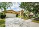 Inviting single-story home featuring a spacious driveway and lush green lawn at 9229 Dayflower Dr, Tampa, FL 33647