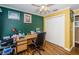 Office featuring yellow and green walls, hard wood floors, closet and a large desk with a rolling chair at 9229 Dayflower Dr, Tampa, FL 33647