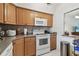 Well-lit kitchen featuring ample counter space, white appliances, and natural wood cabinetry at 9945 47Th N Ave # 208, St Petersburg, FL 33708