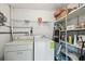 A practical laundry room with a washer, a dryer, and shelving for storage at 9945 47Th N Ave # 208, St Petersburg, FL 33708