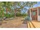 Lush backyard featuring mature tree, outdoor seating, screened porch and wood deck at 10119 Cliff Cir, Tampa, FL 33612