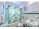 Charming bathroom featuring a floral shower curtain, pastel green tile, and classic fixtures at 10119 Cliff Cir, Tampa, FL 33612
