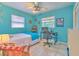 Bright bedroom with blue walls, ceiling fan, and desk area near a window at 10119 Cliff Cir, Tampa, FL 33612