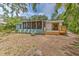 Home exterior featuring a screened porch, wooden deck and a lush backyard at 10119 Cliff Cir, Tampa, FL 33612