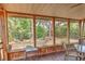 Bright screened porch with wooden floors, seating, and views of the backyard at 10119 Cliff Cir, Tampa, FL 33612