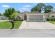 Well-maintained single-story home with a lush green lawn, mature trees, and a spacious driveway at 11026 Austin Ct, New Port Richey, FL 34654