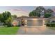 Charming single-story home with well-manicured lawn and attached two-car garage at sunset at 11026 Austin Ct, New Port Richey, FL 34654