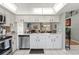 Stylish kitchen with stainless steel appliances, white cabinetry and an opening looking into the living area at 11026 Austin Ct, New Port Richey, FL 34654