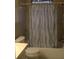 Compact bathroom featuring a shower and bathtub combination with a blue and white patterned shower curtain at 1146 Alma St, Clearwater, FL 33756