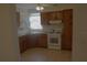 A well lit kitchen featuring wooden cabinetry, neutral countertops, tile floors and a white gas range at 1146 Alma St, Clearwater, FL 33756