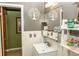 Cozy bathroom with tree art, decorative mirror, sink, and shelving at 12213 Floral Ln, Thonotosassa, FL 33592
