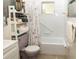 Functional bathroom with a lilac toilet, shower/tub combo, shelving, and towel rack at 12213 Floral Ln, Thonotosassa, FL 33592