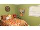 Cozy bedroom with an orange patterned comforter, Simpsons plushies and a window at 12213 Floral Ln, Thonotosassa, FL 33592