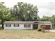 Charming single-story home with a well-maintained lawn and complemented by mature trees in a serene setting at 12213 Floral Ln, Thonotosassa, FL 33592