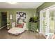 Cozy living room area with a chaise lounge, green walls, and decor at 12213 Floral Ln, Thonotosassa, FL 33592