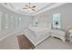 Bright bedroom featuring white furniture, tray ceiling, and multiple windows for ample natural light at 1312 Fishing Lake Dr, Odessa, FL 33556