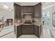 Gourmet kitchen with dark cabinetry, tile backsplash, and modern appliances at 1312 Fishing Lake Dr, Odessa, FL 33556