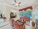 Elegant living room with a ceiling fan, pool view, and ornate furniture at 1312 Fishing Lake Dr, Odessa, FL 33556