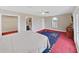 Spacious main bedroom boasts red carpet, a bed, and arched window at 1312 Fishing Lake Dr, Odessa, FL 33556
