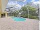 A covered pool area featuring a kidney-shaped pool, a brick-paved patio, and a screened enclosure at 1312 Fishing Lake Dr, Odessa, FL 33556