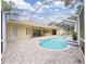 Backyard pool area featuring brick pavers, a screened enclosure, and access to the home's multiple entry points at 1312 Fishing Lake Dr, Odessa, FL 33556