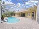 A sunny pool area with a screened enclosure, a spacious brick patio, and steps leading into the refreshing pool at 1312 Fishing Lake Dr, Odessa, FL 33556