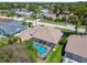 Beautiful aerial view of the home with a screened-in pool, and lush surroundings within a residential neighborhood at 13553 Glaze Brook Dr, Hudson, FL 34667
