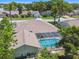 Wide aerial view of the home showcasing its screened-in pool and the mature landscaping at 13553 Glaze Brook Dr, Hudson, FL 34667