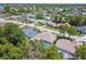 Neighborhood aerial showcasing houses with pools and lush landscaping under a clear blue sky at 13553 Glaze Brook Dr, Hudson, FL 34667