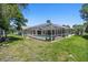 Lush backyard featuring a screened-in pool and patio, ideal for outdoor gatherings and leisure at 13553 Glaze Brook Dr, Hudson, FL 34667