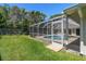 Green grassy backyard showcasing a screened-in pool and patio area, great for entertaining at 13553 Glaze Brook Dr, Hudson, FL 34667