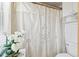 Cozy bathroom featuring a decorative shower curtain, white cabinets, and natural light from a window at 13553 Glaze Brook Dr, Hudson, FL 34667