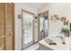 Bright bathroom with tile floor, direct pool access, and decorative floral accents at 13553 Glaze Brook Dr, Hudson, FL 34667