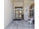 Inviting home entrance with a tiled porch, seating area, and double doors with decorative details at 13553 Glaze Brook Dr, Hudson, FL 34667