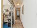 Hallway with tile flooring leads to various rooms, including an office with glass sliding doors at 13553 Glaze Brook Dr, Hudson, FL 34667