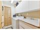 Functional laundry room with washer, dryer, overhead cabinets, and a wash sink with a faucet at 13553 Glaze Brook Dr, Hudson, FL 34667