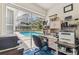 Home office with a view of the screened pool area, providing a bright workspace at 13553 Glaze Brook Dr, Hudson, FL 34667