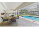 Covered patio with dining set, ceiling fan, and screened-in pool area at 13553 Glaze Brook Dr, Hudson, FL 34667