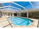 Enclosed pool features a clear blue sky, brick pavers, and access to the home at 13553 Glaze Brook Dr, Hudson, FL 34667