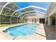 Sparkling pool with screened enclosure, patio, and lush landscaping at 13553 Glaze Brook Dr, Hudson, FL 34667