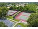 Aerial view of the community tennis courts, with lush greenery, trees, and surrounding walking paths at 13553 Glaze Brook Dr, Hudson, FL 34667