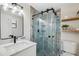 Modern bathroom with glass shower, blue accent tiles, and floating shelves is luxurious at 13810 Malcolm Ave, Hudson, FL 34667