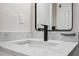 Close-up view of the bathroom vanity featuring white countertop, black faucet, and large mirror at 13810 Malcolm Ave, Hudson, FL 34667
