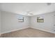 Bright, empty bedroom with two windows, ceiling fan, and light wood-look flooring at 13810 Malcolm Ave, Hudson, FL 34667